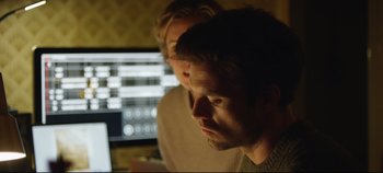 Movie still from “Monday” (2020), directed by Argyris Papadimitropoulos – Two men looking at a computer screen in front of a computer; Close Up shot, Over the shoulder angle