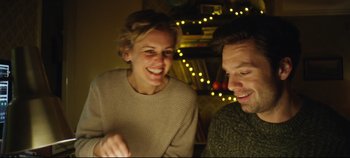 Movie still from “Monday” (2020), directed by Argyris Papadimitropoulos – A man and a woman sitting next to each other in front of lights; Medium shot, Low angle