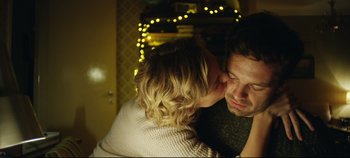 Movie still from “Monday” (2020), directed by Argyris Papadimitropoulos – A man and a woman kissing in front of christmas lights; Close Up shot, Over the shoulder angle