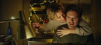 Movie still from “Monday” (2020), directed by Argyris Papadimitropoulos – A man and a woman hugging in front of a computer; Medium shot, Low angle