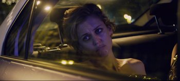 Movie still from “Monday” (2020), directed by Argyris Papadimitropoulos – A woman sitting in the back seat of a car at night; Close Up shot, Over the shoulder angle