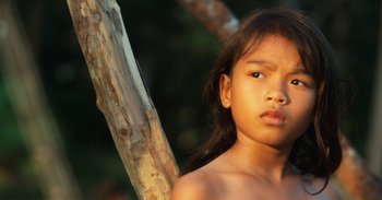Movie still from “First They Killed My Father” (2017), directed by Angelina Jolie – A young girl standing in front of a tree; Close Up shot, High angle
