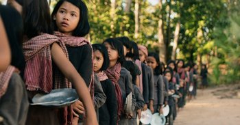 Movie still from “First They Killed My Father” (2017), directed by Angelina Jolie – A group of young girls standing in a line; Medium shot, High angle