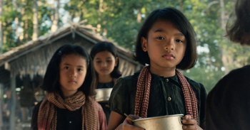 Movie still from “First They Killed My Father” (2017), directed by Angelina Jolie – A group of young girls standing next to each other; Medium shot, Over the shoulder angle