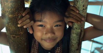 Movie still from “First They Killed My Father” (2017), directed by Angelina Jolie – A child with his hands on his head; Close Up shot, Overhead angle