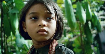 Movie still from “First They Killed My Father” (2017), directed by Angelina Jolie – A child with a plant in the background; Close Up shot, Low angle