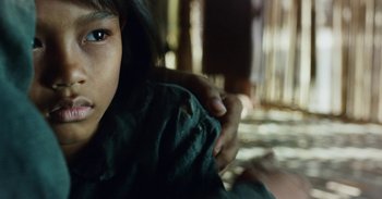 Movie still from “First They Killed My Father” (2017), directed by Angelina Jolie – A child's face and hands; Close Up shot, Over the shoulder angle