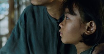 Movie still from “First They Killed My Father” (2017), directed by Angelina Jolie – A young person looking up; Close Up shot, Over the shoulder angle