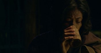 Movie still from “First They Killed My Father” (2017), directed by Angelina Jolie – A woman holding a piece of wood in her hands; Extreme Close Up shot, Low angle