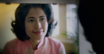 Movie still from “First They Killed My Father” (2017), directed by Angelina Jolie – A woman in a pink shirt is looking at the camera; Close Up shot, Over the shoulder angle