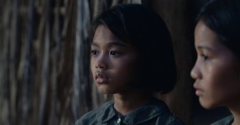 Movie still from “First They Killed My Father” (2017), directed by Angelina Jolie – A little girl is looking into the distance; Close Up shot, Over the shoulder angle