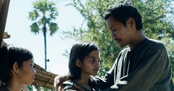 Movie still from “First They Killed My Father” (2017), directed by Angelina Jolie – A man and a woman standing next to each other; Medium shot, Over the shoulder angle