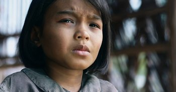 Movie still from “First They Killed My Father” (2017), directed by Angelina Jolie – A young girl's face; Close Up shot, Over the shoulder angle