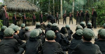 Movie still from “First They Killed My Father” (2017), directed by Angelina Jolie – A group of people in the woods with hats on; Wide shot, High angle