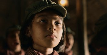 Movie still from “First They Killed My Father” (2017), directed by Angelina Jolie – A child wearing a hat; Close Up shot, Low angle