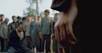 Movie still from “First They Killed My Father” (2017), directed by Angelina Jolie – A group of men standing in front of each other; Medium shot, Low angle