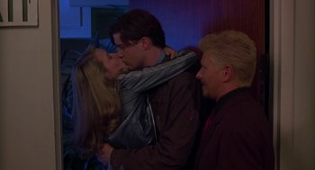 Movie still from “Monkeybone” (2001), directed by Henry Selick – A man and a woman kissing each other in front of another man; Medium shot, Over the shoulder angle
