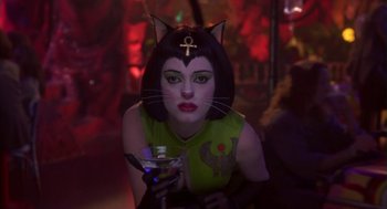 Movie still from “Monkeybone” (2001), directed by Henry Selick – A woman in a cat costume holding a glass of wine; Close Up shot, Over the shoulder angle