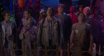 Movie still from “Monkeybone” (2001), directed by Henry Selick – A group of people standing next to each other in front of a fence; Medium shot, Low angle