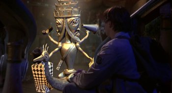 Movie still from “Monkeybone” (2001), directed by Henry Selick – A woman sitting in front of a statue of a person with a horn; Medium shot, Over the shoulder angle