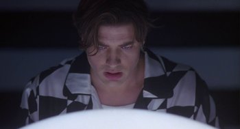 Movie still from “Monkeybone” (2001), directed by Henry Selick – A man with long hair and a checkered shirt looking at the camera; Close Up shot, Low angle