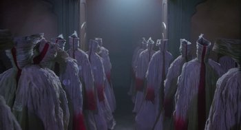 Movie still from “Monkeybone” (2001), directed by Henry Selick – A group of people dressed in white and red standing next to each other in a room; Wide shot, Low angle
