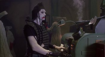 Movie still from “Monkeybone” (2001), directed by Henry Selick – A person with a face paint on playing a keyboard; Medium shot, Low angle