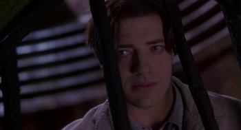 Movie still from “Monkeybone” (2001), directed by Henry Selick – A young man is looking through bars in a dark room; Close Up shot, Low angle
