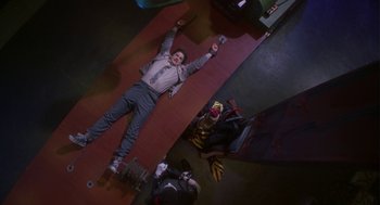 Movie still from “Monkeybone” (2001), directed by Henry Selick – A man laying on the ground holding a skateboard; Wide shot, Overhead angle