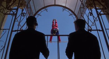 Movie still from “Monkeybone” (2001), directed by Henry Selick – A man hanging upside down from a metal structure; Wide shot, Low angle