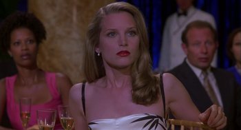 Movie still from “Monkeybone” (2001), directed by Henry Selick – A woman with long hair and red lipstick sitting at a table with a glass of wine; Close Up shot, Over the shoulder angle