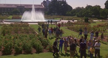 Movie still from “Monkeybone” (2001), directed by Henry Selick – A group of people standing in a field near a fountain; Extreme Wide shot, High angle