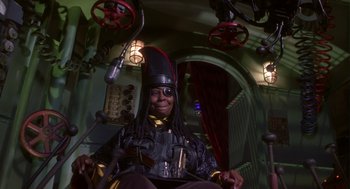 Movie still from “Monkeybone” (2001), directed by Henry Selick – A man with a hat and a microphone in a room; Medium shot, Low angle