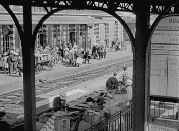 Movie still from “Monsieur Hulot's Holiday” (1953), directed by Jacques Tati – A black and white photo of a train station; Extreme Wide shot, High angle