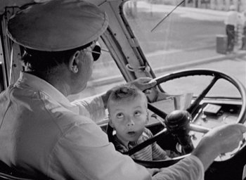 Movie still from “Monsieur Hulot's Holiday” (1953), directed by Jacques Tati – An old photo of a man and a child in a car; Close Up shot, High angle