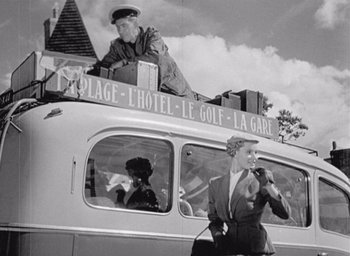 Movie still from “Monsieur Hulot's Holiday” (1953), directed by Jacques Tati – A couple of women are sitting on top of a bus; Medium shot, Low angle