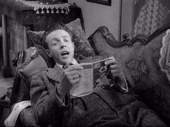 Movie still from “Monsieur Verdoux” (1947), directed by Charles Chaplin – A black and white photo of a man reading a newspaper; Medium shot, High angle