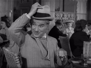 Movie still from “Monsieur Verdoux” (1947), directed by Charles Chaplin – An older man wearing a suit and tie and a hat; Medium shot, Low angle