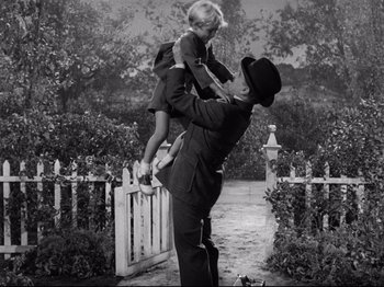 Movie still from “Monsieur Verdoux” (1947), directed by Charles Chaplin – An old photo of a man holding a little girl; Wide shot, High angle