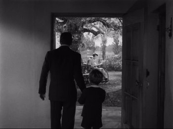 Movie still from “Monsieur Verdoux” (1947), directed by Charles Chaplin – A man and a boy are walking through a door way; Wide shot, Over the shoulder angle