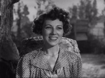 Movie still from “Monsieur Verdoux” (1947), directed by Charles Chaplin – An old black and white photo of a woman smiling for the camera; Close Up shot, Low angle