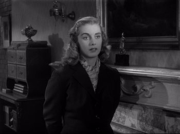 Movie still from “Monsieur Verdoux” (1947), directed by Charles Chaplin – A black and white photo of a woman in a suit; Medium shot, Over the shoulder angle