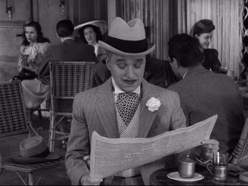 Movie still from “Monsieur Verdoux” (1947), directed by Charles Chaplin – A black and white photo of a man reading a newspaper; Medium shot, High angle