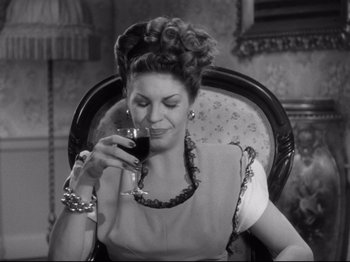 Movie still from “Monsieur Verdoux” (1947), directed by Charles Chaplin – A woman sitting in a chair holding a glass of wine; Close Up shot, Low angle