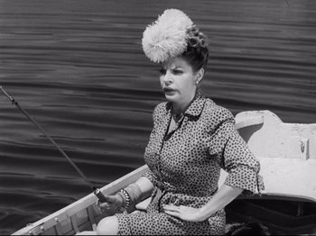 Movie still from “Monsieur Verdoux” (1947), directed by Charles Chaplin – An old photo of a woman sitting in a boat on the water; Medium shot, High angle