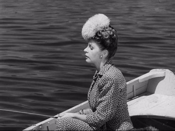 Movie still from “Monsieur Verdoux” (1947), directed by Charles Chaplin – A woman sitting on a boat on a body of water; Medium shot, High angle