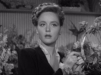 Movie still from “Monsieur Verdoux” (1947), directed by Charles Chaplin – A black - and - white photo of a woman holding flowers; Close Up shot, Low angle