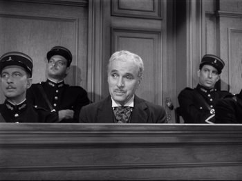 Movie still from “Monsieur Verdoux” (1947), directed by Charles Chaplin – A black and white photo of a man sitting in a courtroom; Medium shot, Over the shoulder angle