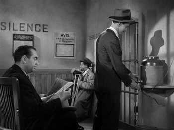 Movie still from “Monsieur Verdoux” (1947), directed by Charles Chaplin – A man in a suit and a hat standing next to another man in a suit and a hat; Wide shot, Low angle