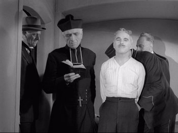 Movie still from “Monsieur Verdoux” (1947), directed by Charles Chaplin – A group of men standing next to each other in a room; Medium shot, Low angle